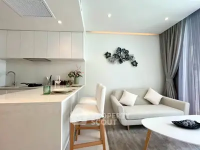 Modern open-layout kitchen and living room with elegant decor and natural light.