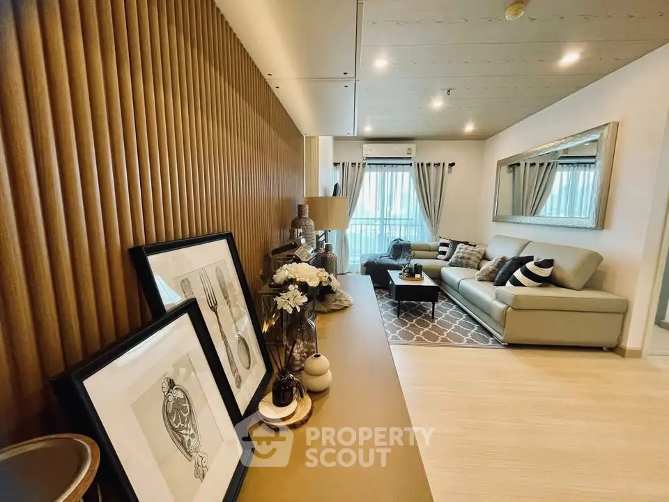 Stylish modern living room with elegant decor and large mirror enhancing space.