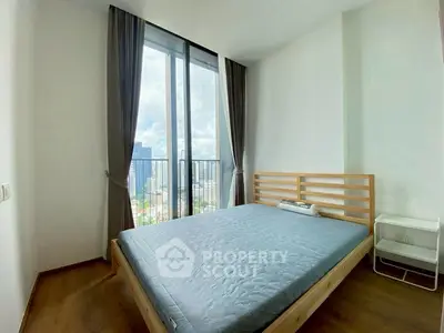 Spacious bedroom with large window offering stunning city views, featuring a minimalist wooden bed and elegant curtains.