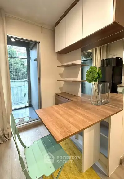 Modern kitchen with open layout and balcony access, featuring sleek cabinetry and stylish decor.