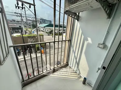 Charming small balcony with urban view, perfect for enjoying morning coffee in a vibrant neighborhood.