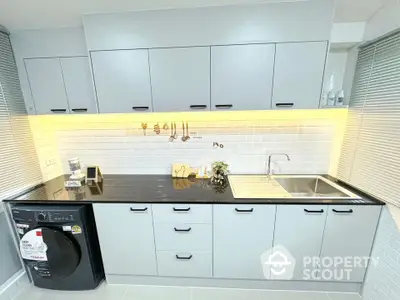 Modern kitchen with sleek cabinets and washing machine