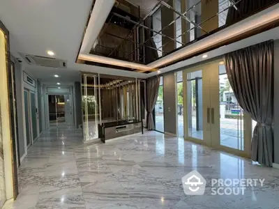 Luxurious marble-floored living room with elegant mirrored ceiling and large windows