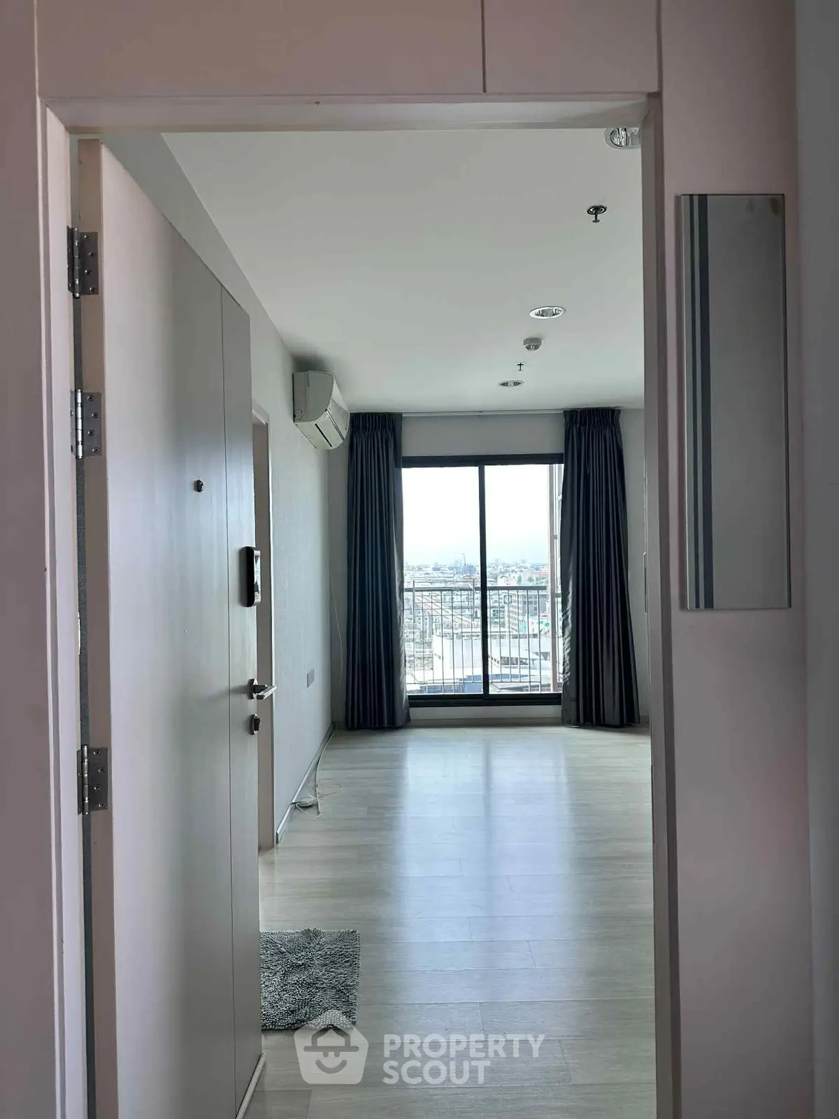 Spacious apartment entrance with large windows and balcony view