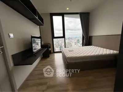 Modern bedroom with city view, featuring sleek furniture and large window for natural light.