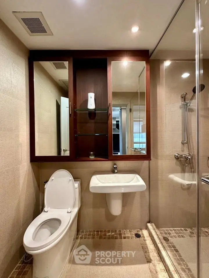 Modern bathroom with glass shower and sleek fixtures in a contemporary apartment.