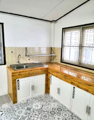 Charming kitchen with vintage tile flooring and modern cabinetry, perfect for culinary enthusiasts.