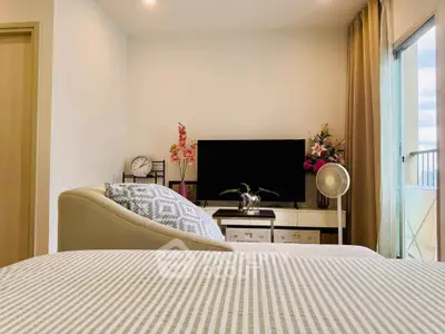 Modern bedroom with stylish decor and balcony view, featuring a cozy bed, TV, and elegant furnishings.