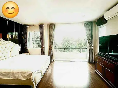 Spacious bedroom with elegant decor and large windows offering natural light and scenic views.