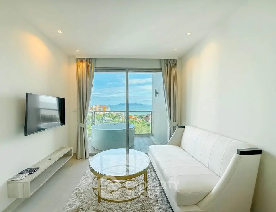 Modern living room with ocean view and balcony, featuring sleek furniture and a luxurious ambiance.