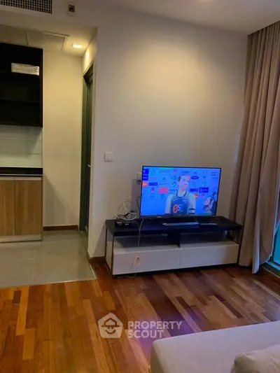 Modern living room with wooden flooring and sleek TV setup