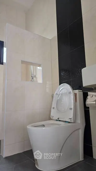 Modern bathroom with sleek toilet and stylish black and white tile design
