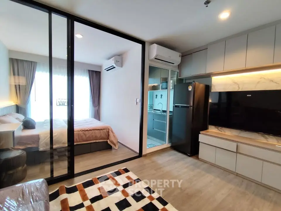 Modern studio apartment with open layout, featuring a cozy bedroom and sleek kitchen.