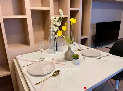 Elegant dining setup in modern living room with stylish shelving and TV unit.