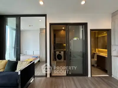 Modern apartment interior with open living space, bedroom, and kitchen featuring sleek design and natural light.