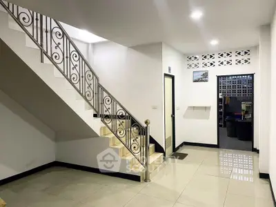 Spacious modern interior with elegant staircase and polished tile flooring