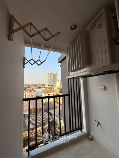 Compact balcony with city view and air conditioning unit, ideal for urban living.