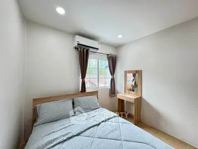 Cozy bedroom with natural light and modern furnishings, featuring a comfortable bed and stylish decor.
