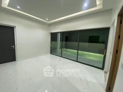 Modern interior with marble flooring and sliding glass doors leading to a pool view.