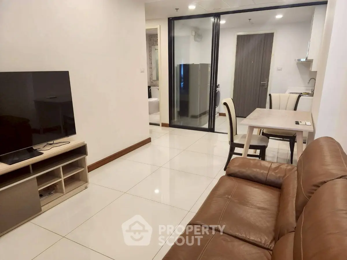 Modern living room with leather sofa and open kitchen in stylish apartment