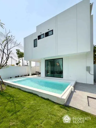 Modern minimalist house with private pool and lush green lawn