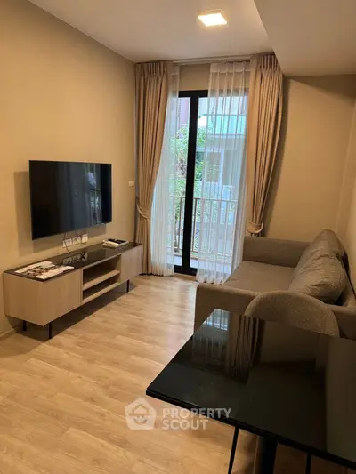 Modern living room with sleek TV setup and cozy sofa, featuring elegant curtains and wooden flooring.