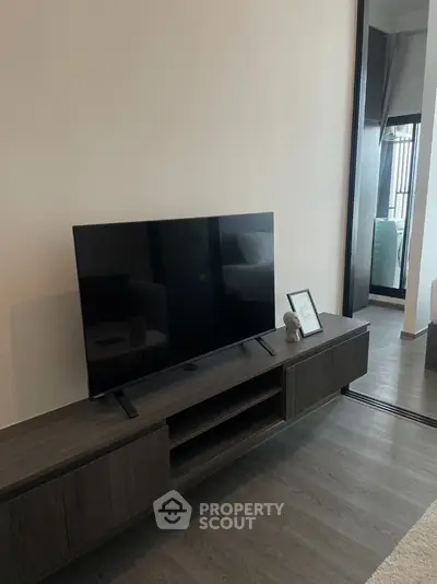 Modern living room with sleek TV stand and large flat-screen TV, perfect for entertainment.