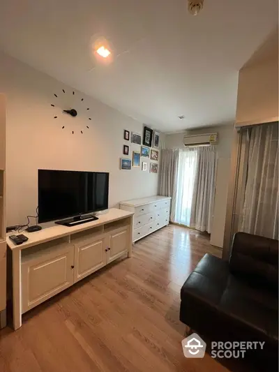 Inviting living room with gleaming hardwood floors, modern furnishings, and abundant natural light streaming through large windows, creating a warm, welcoming space.