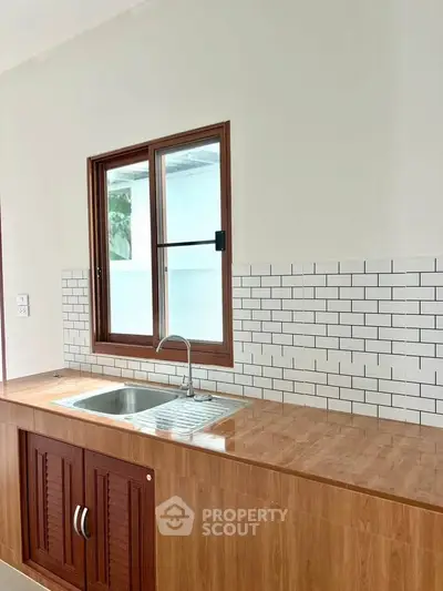 Modern kitchen with wooden cabinetry and sleek subway tile backsplash