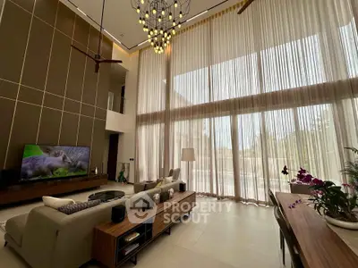 Luxurious high-ceiling living room with modern decor and large windows