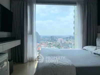 Modern bedroom with stunning city view through large window, featuring sleek furnishings and cozy bedding.