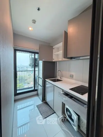 Modern kitchen with sleek appliances and city view from balcony