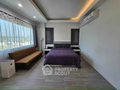 Spacious modern bedroom with large windows and stylish decor