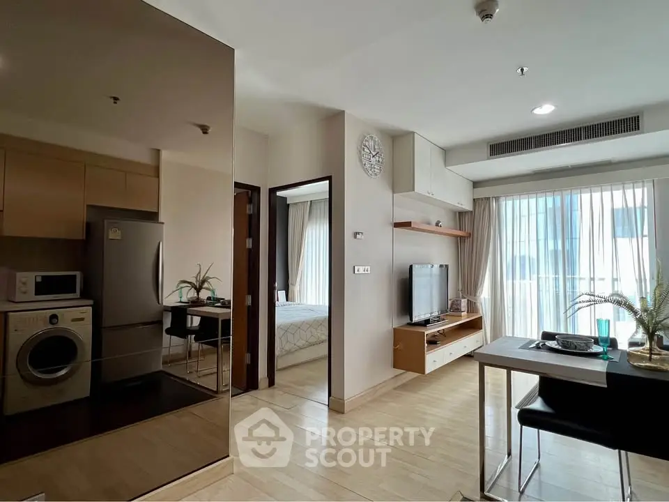 Modern apartment interior with open living and kitchen space, featuring sleek appliances and stylish decor.