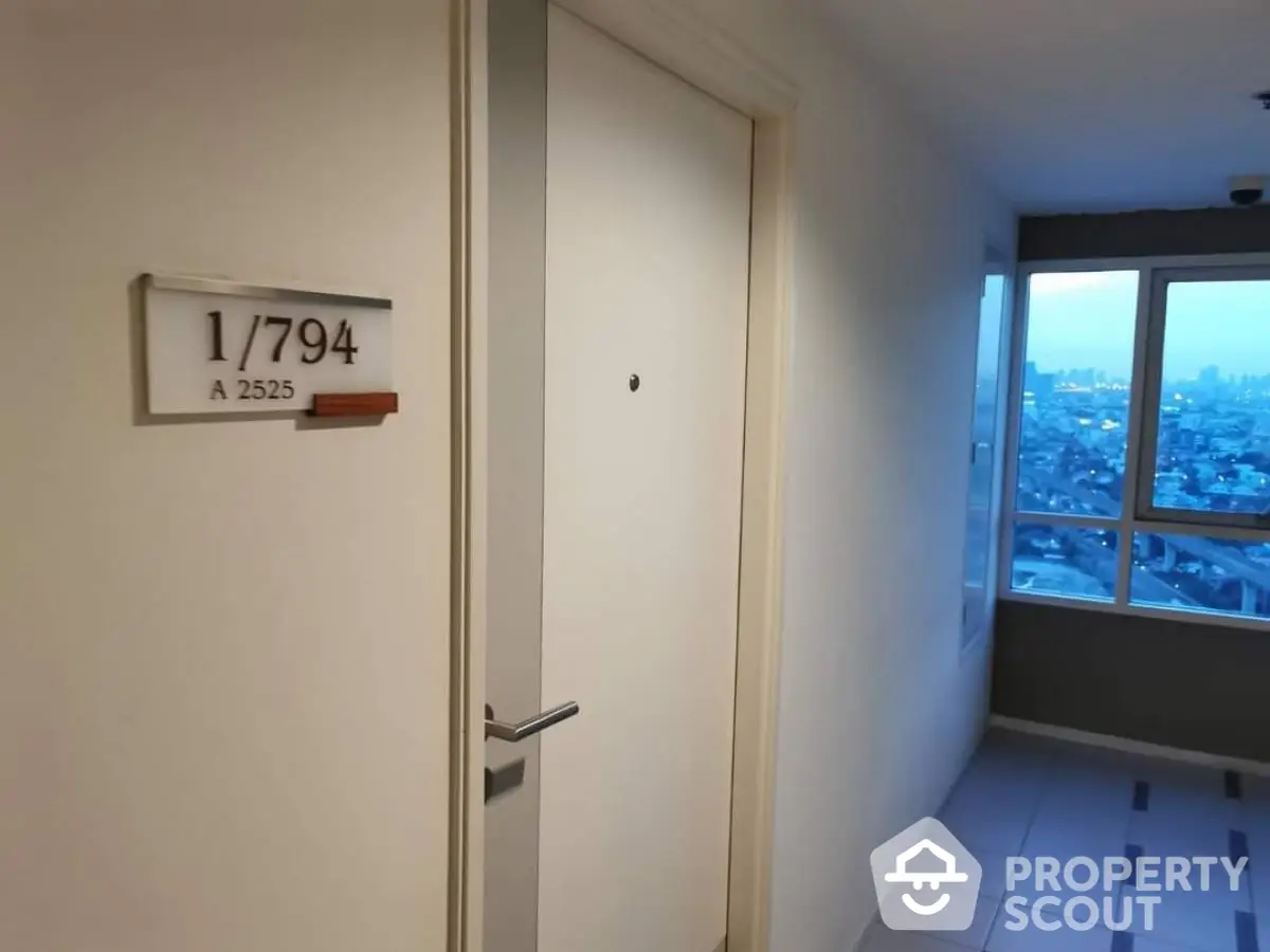 Modern apartment entrance with city view from hallway window