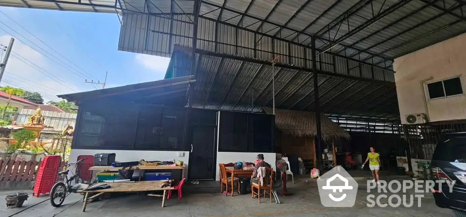 Spacious outdoor area with covered roof and seating, ideal for gatherings and activities.