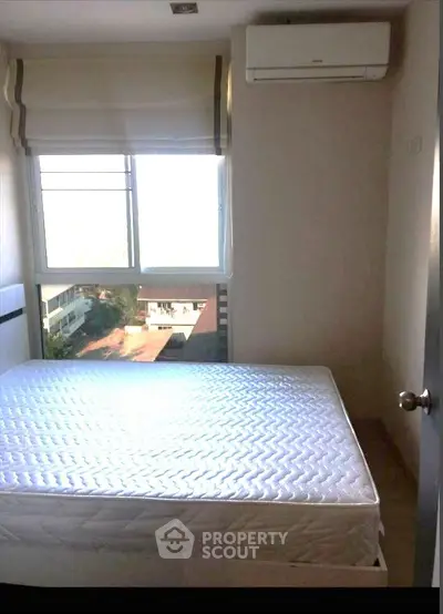 Cozy bedroom with natural light and air conditioning in modern apartment.