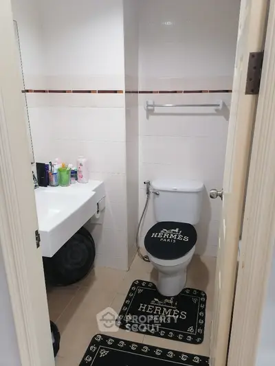 Compact bathroom with Hermes-themed decor and modern fixtures
