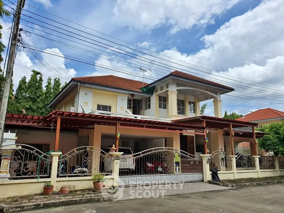 Charming two-story house with red roof and spacious front yard in a serene neighborhood.
