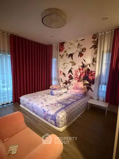 Charming bedroom with floral accent wall and cozy decor, perfect for relaxation.