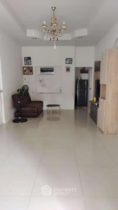 Spacious living room with modern decor and chandelier lighting