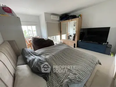 Spacious bedroom with modern decor and large window for natural light