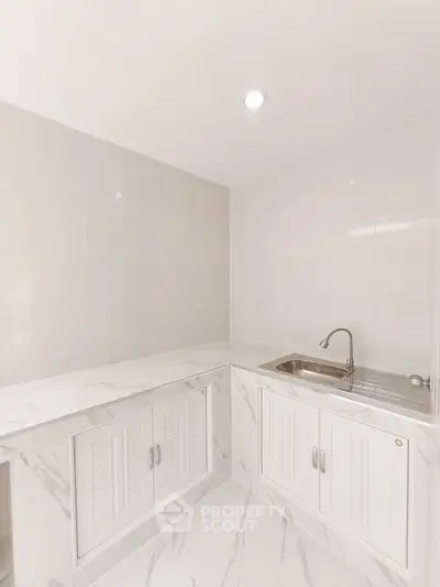 Sleek modern kitchen with marble countertops and stainless steel sink