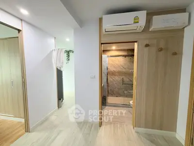 Modern apartment interior with sleek bathroom and air conditioning unit, showcasing contemporary design and functionality.