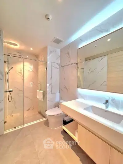Luxurious modern bathroom with elegant marble tiles and spacious shower area.