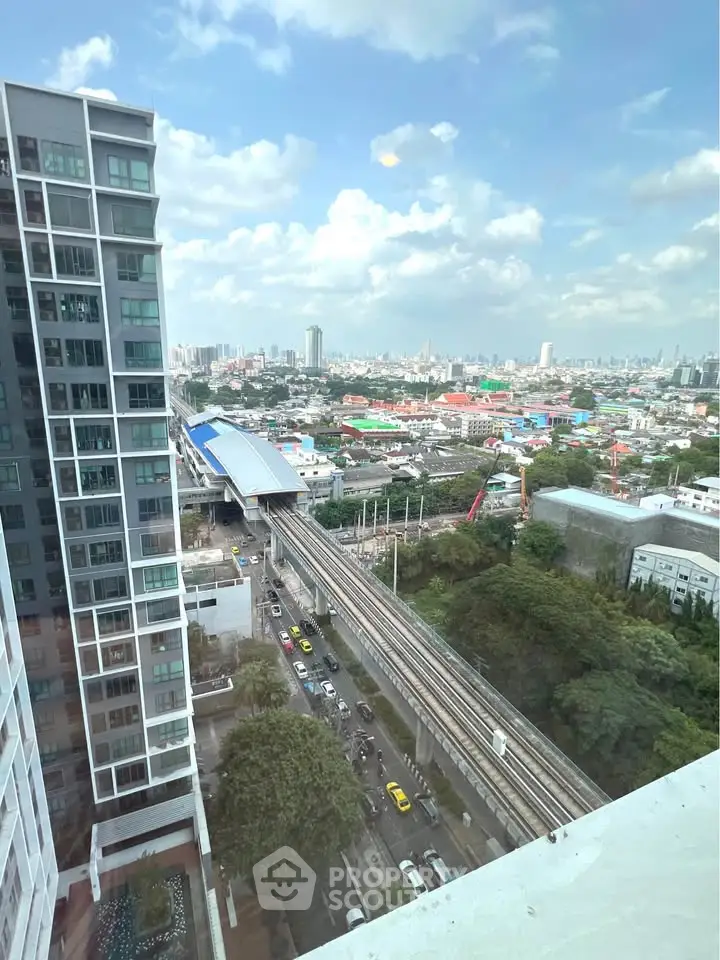 Stunning cityscape view from high-rise building with urban skyline and train tracks.