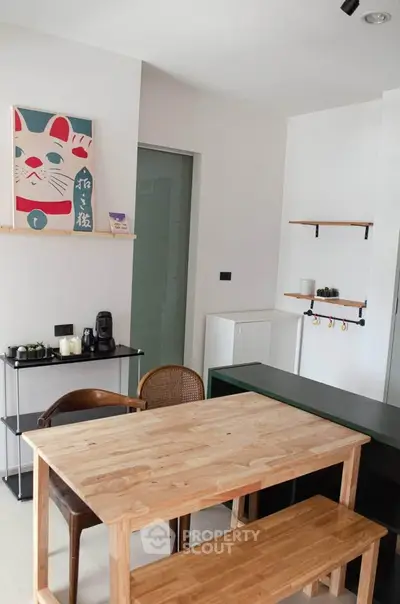 Charming dining area with wooden table and chairs, modern decor, and stylish shelving in a cozy apartment.