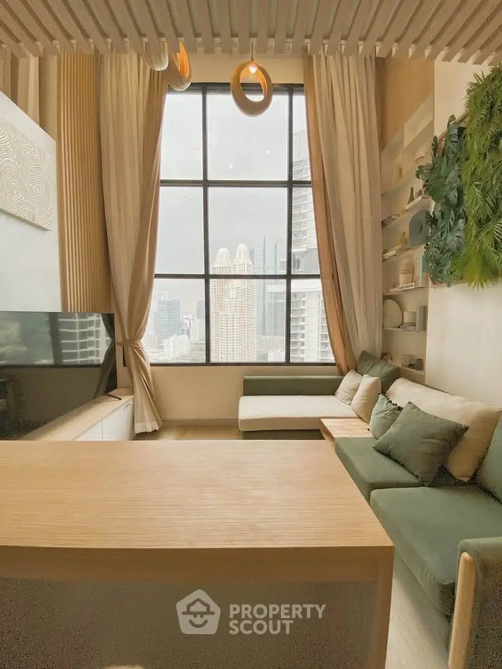 Luxurious living room with large windows offering stunning city views, elegant decor, and cozy seating area.