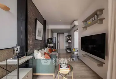 Modern living room with stylish decor, wall-mounted TV, and open layout leading to kitchen.