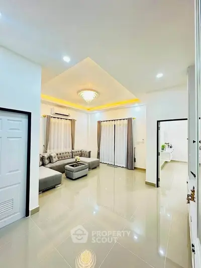 Spacious modern living room with elegant lighting and plush gray sectional sofa.
